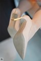 A close up of a woman's shoes on a table.