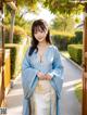 A woman in a blue and white kimono standing in front of a door.