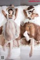 A woman in a maid outfit laying on a bed.