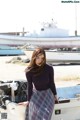 A woman standing on top of a boat next to a boat.