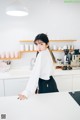 A woman standing at a counter in a kitchen.