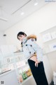 A woman standing in front of a counter in a store.