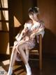 A woman in a kimono sitting on a chair.